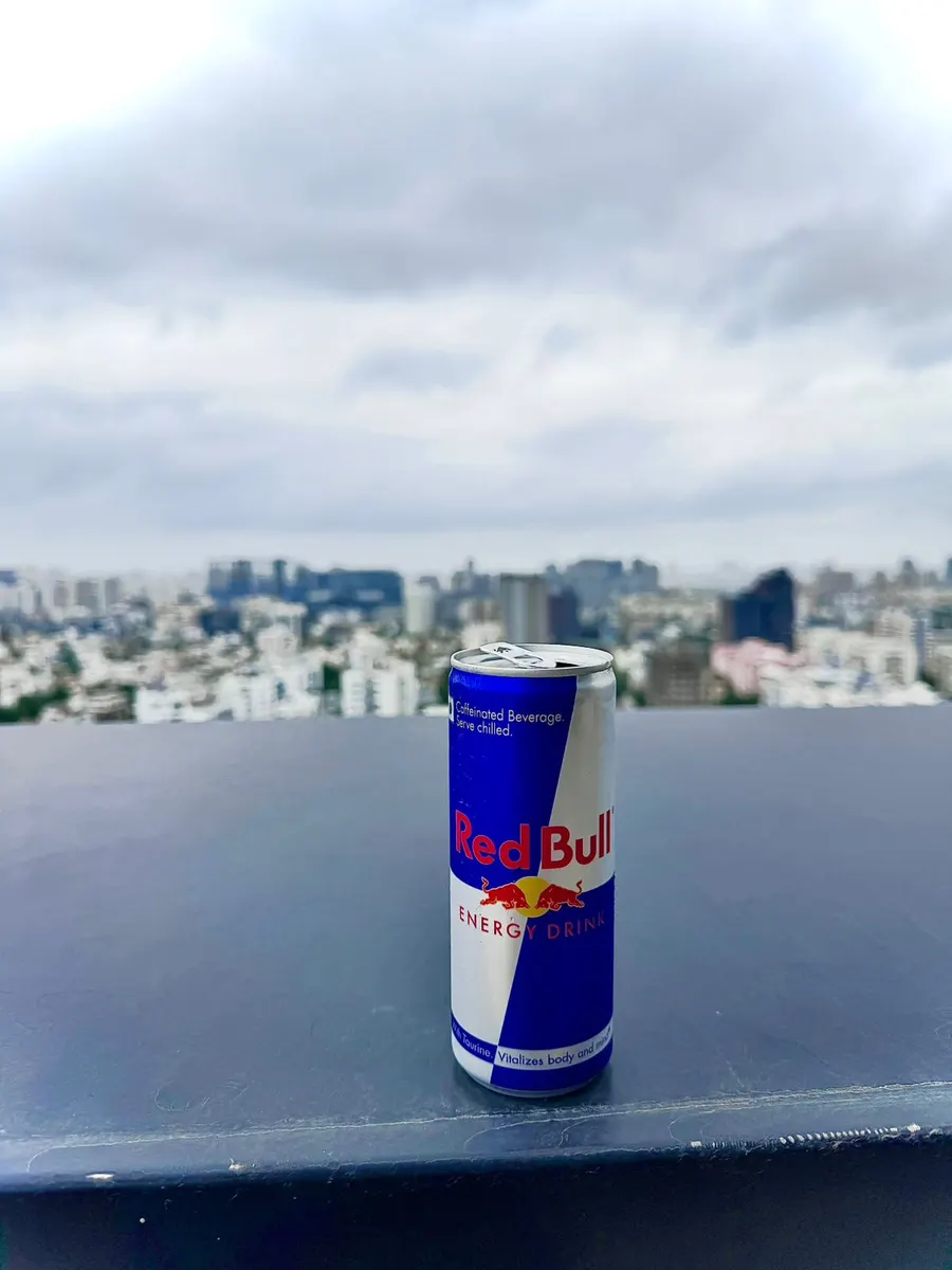 A can of Red Bull balanced on a ledge above the Pune skyline