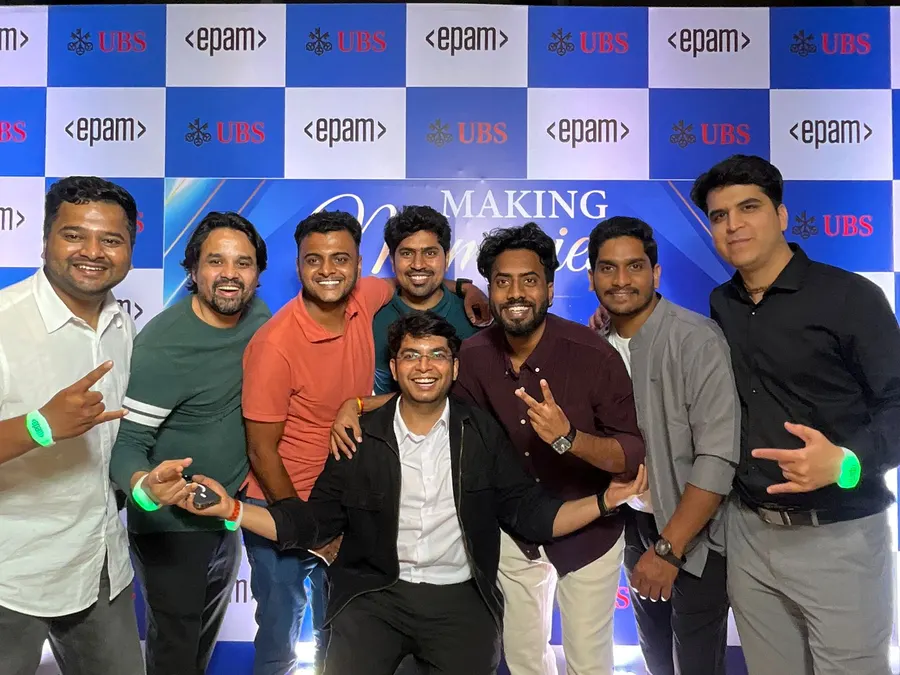 Team photo at a UBS and EPAM event in front of a branded backdrop